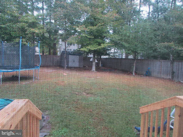 a front view of a house with a garden and trees