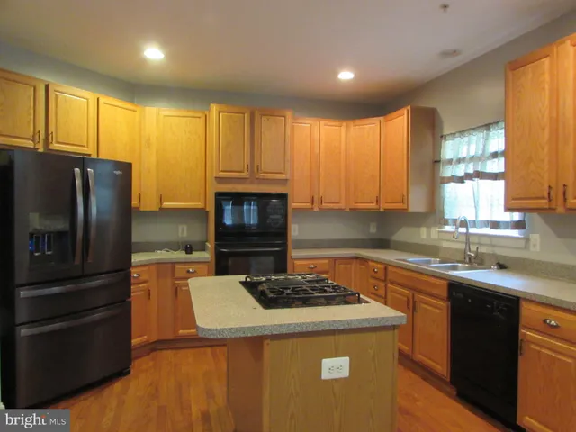 a kitchen with a refrigerator a stove and a sink
