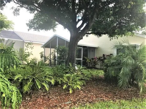 a view of a house with a yard and sitting area