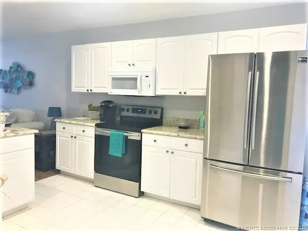 a kitchen with a refrigerator sink and cabinets