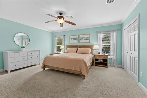 a spacious bedroom with a bed and a chandelier