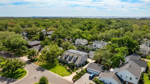 an aerial view of a house with a yard and lake view