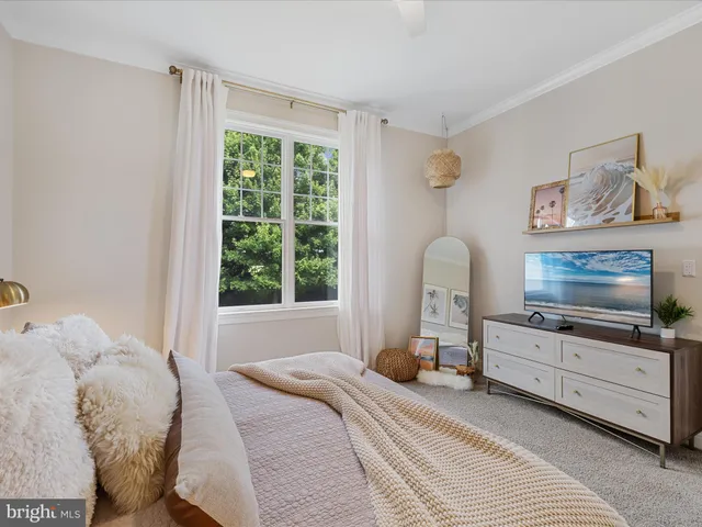 a bedroom with a bed and large windows