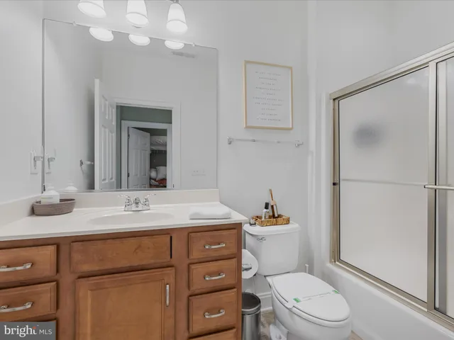 a bathroom with a granite countertop sink toilet a mirror and shower