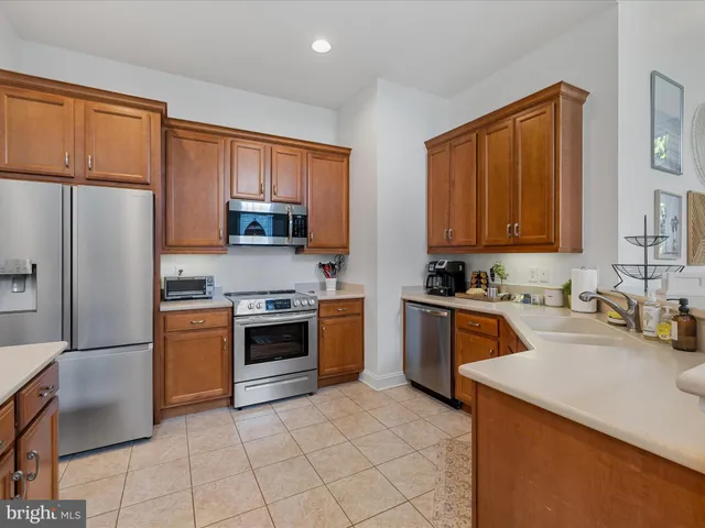 a kitchen with stainless steel appliances granite countertop a refrigerator stove top oven and sink
