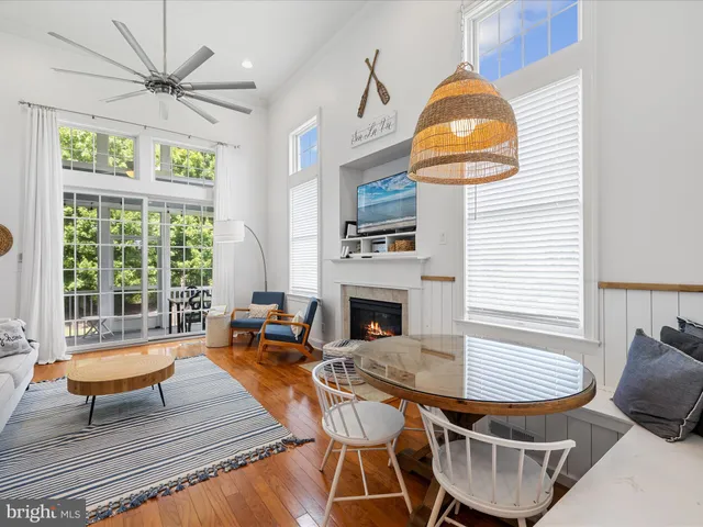 a living room with fireplace a dining table and a chandelier