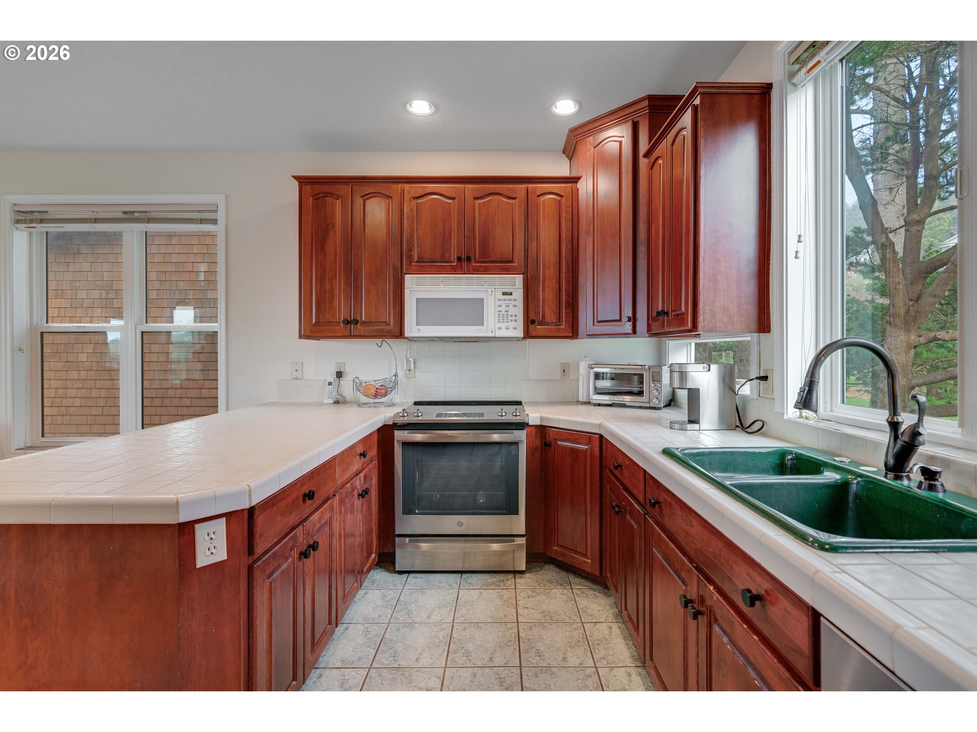 1435 Sunset Avenue Oceanside, OR 97141 - Photo 13 of 46 a kitchen with stainless steel appliances granite countertop a sink a stove and wooden cabinets