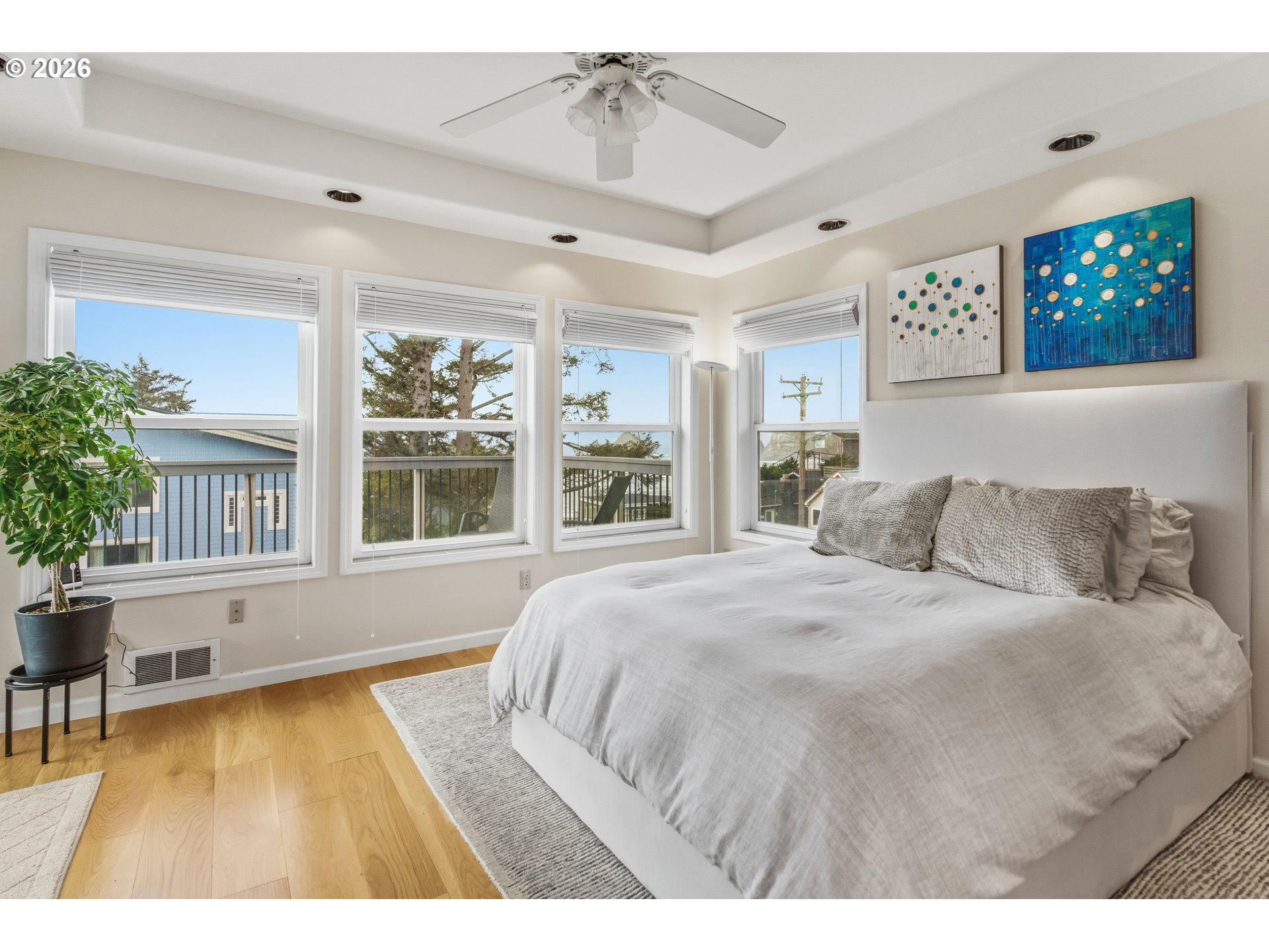 1435 Sunset Avenue Oceanside, OR 97141 - Photo 19 of 46 a spacious bedroom with a large bed a chandelier and windows