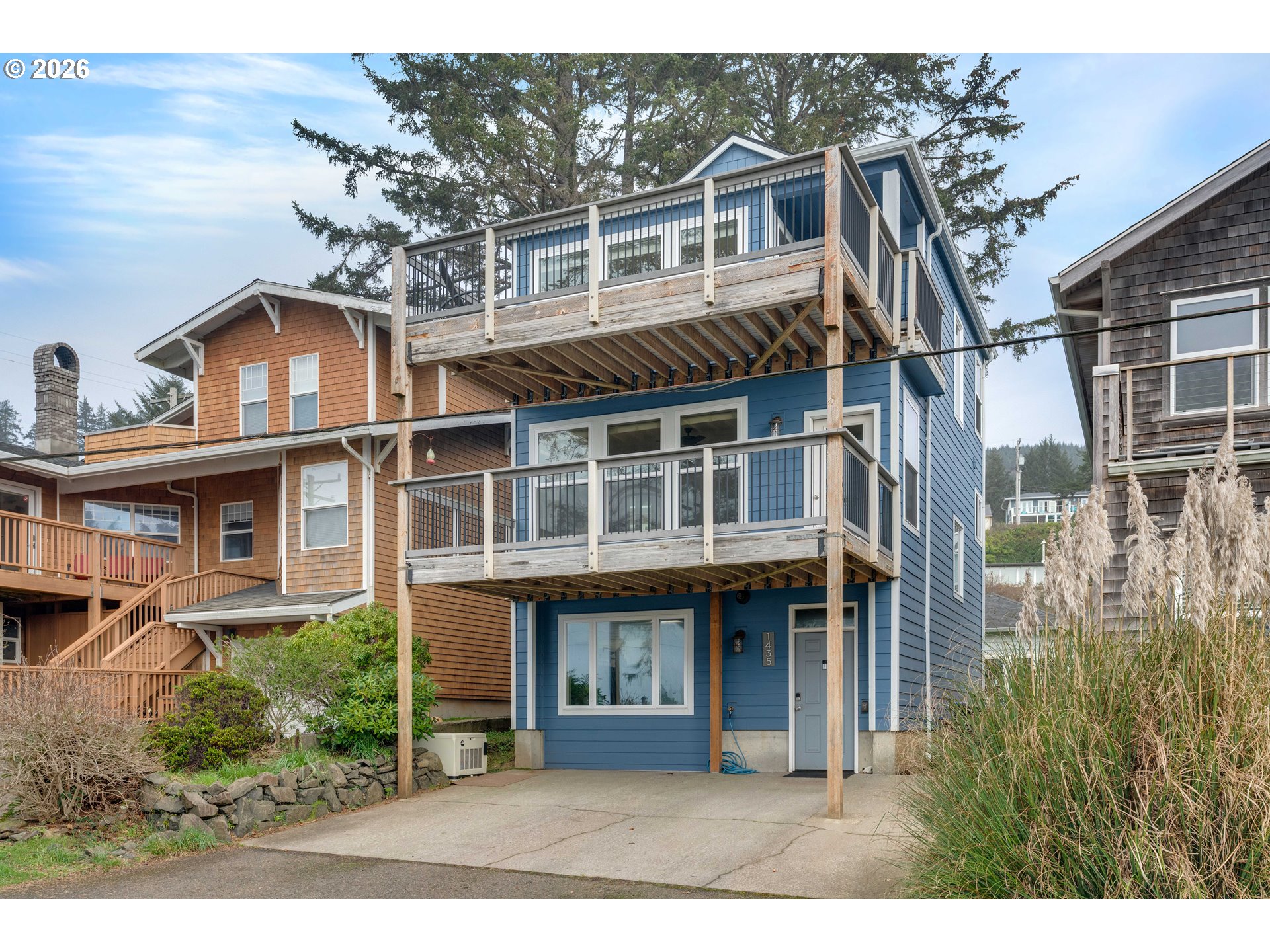 1435 Sunset Avenue Oceanside, OR 97141 - Photo 4 of 46 a view of a white house with large windows and a small yard