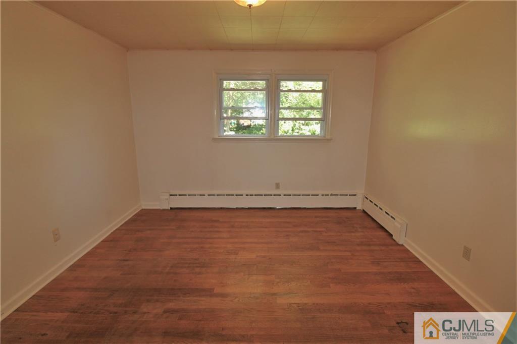 709 Myrtle Road North Brunswick, NJ 08902 - Photo 8 of 16 an empty room with wooden floor and windows