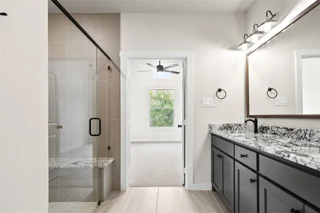 a bathroom with a granite countertop sink double vanity and a mirror