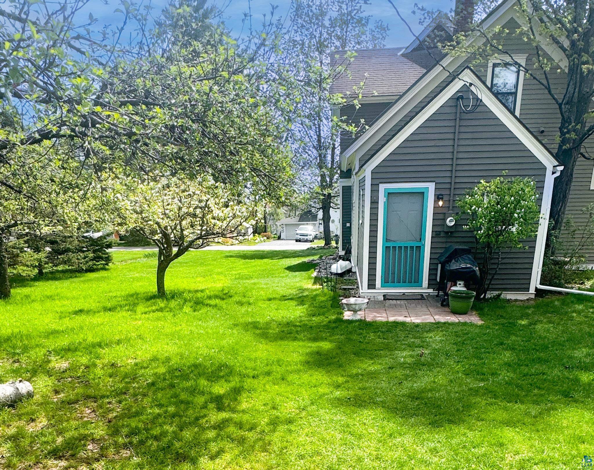 303 East 5th Street Washburn, WI 54891 - Photo 13 of 34 Expansive rear yard featuring mature trees and a vibrant green lawn