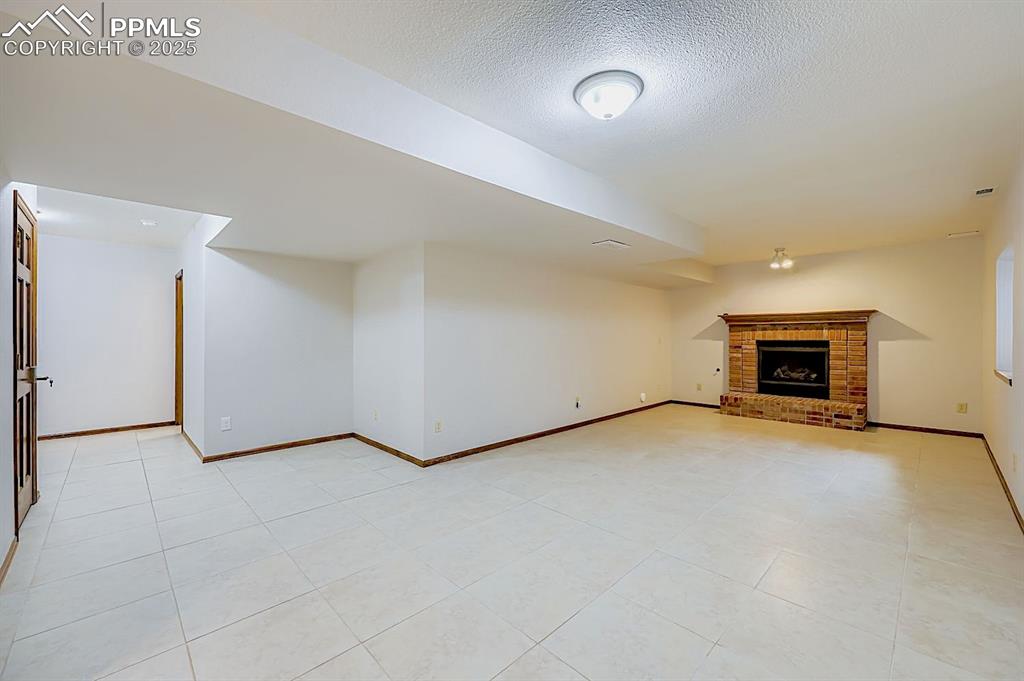 5825 Wilson Road Colorado Springs, CO 80919 - Photo 35 of 48 an empty room with furniture and a fireplace