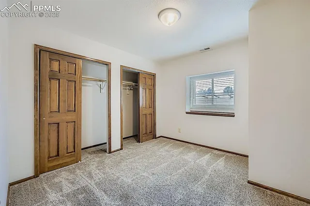 an empty room with windows and closet