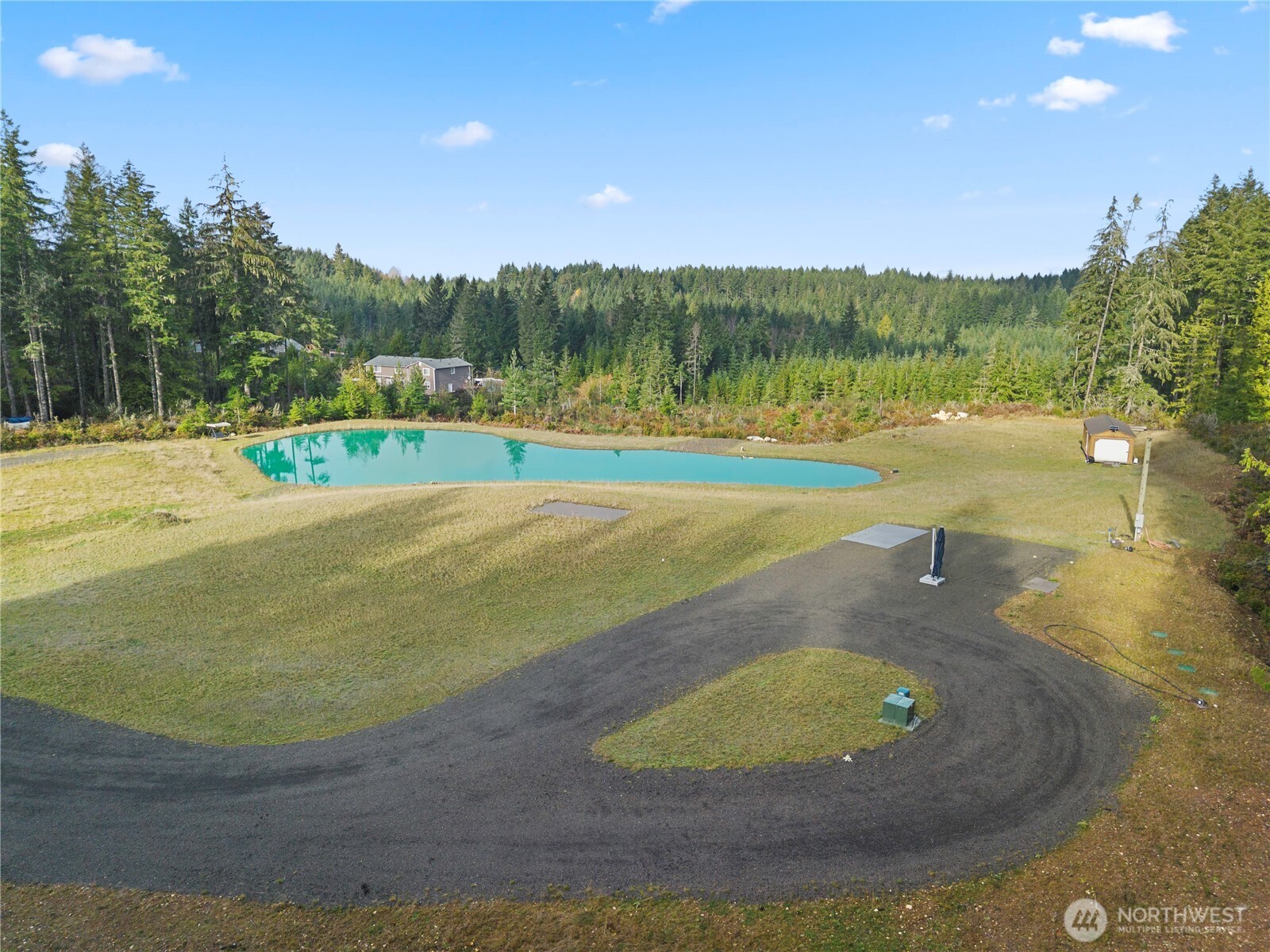 151 East Kingsley Place Belfair, WA 98528 - Photo 2 of 40 a view of a swimming pool with a yard and trees in the background