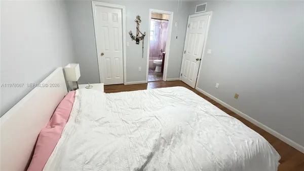 a bedroom with a bed and wooden floor