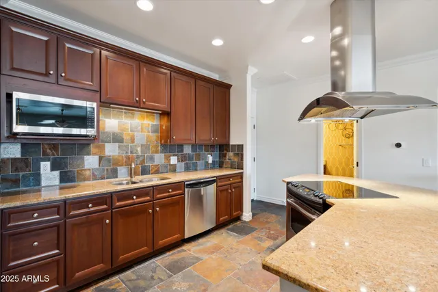 a kitchen with stainless steel appliances granite countertop a sink a stove and cabinets