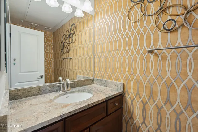 a bathroom with a granite countertop sink and a mirror