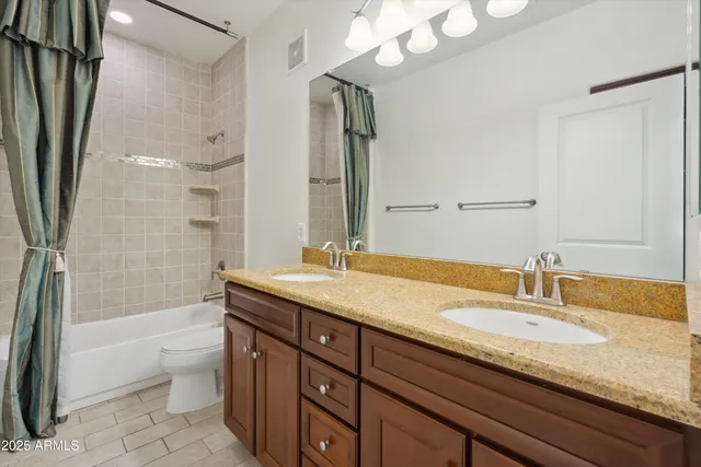 a bathroom with a granite countertop sink a toilet a shower and a mirror