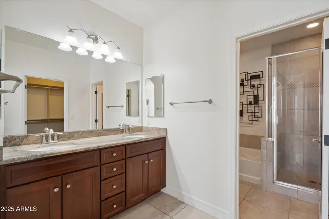 a bathroom with a granite countertop sink a mirror and a shower