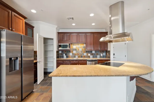 a kitchen with stainless steel appliances granite countertop a sink a refrigerator and a stove