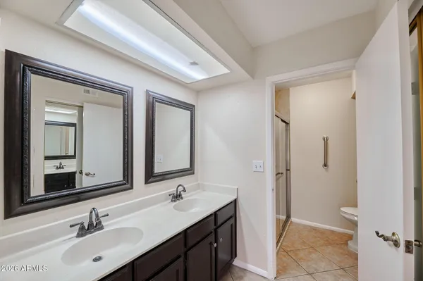 a bathroom with a double vanity sink mirror and toilet