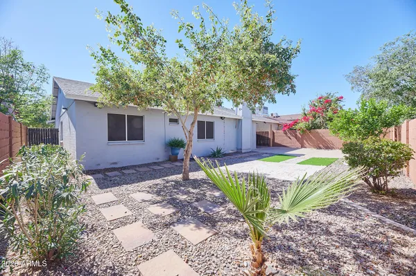 a front view of a house with a yard and potted plants