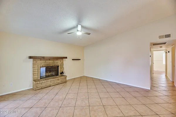an empty room with windows and fireplace