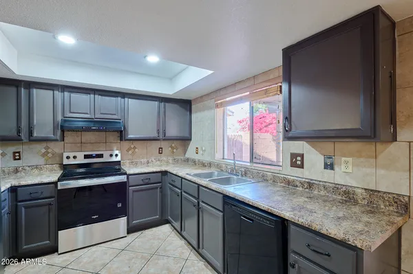a kitchen with stainless steel appliances granite countertop a sink stove and cabinets