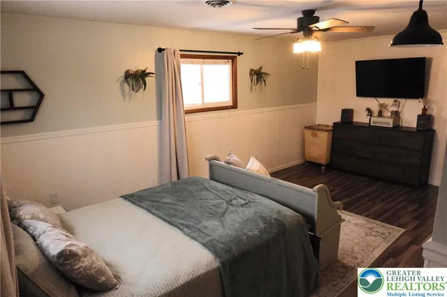 a bedroom with a bed and a flat screen tv