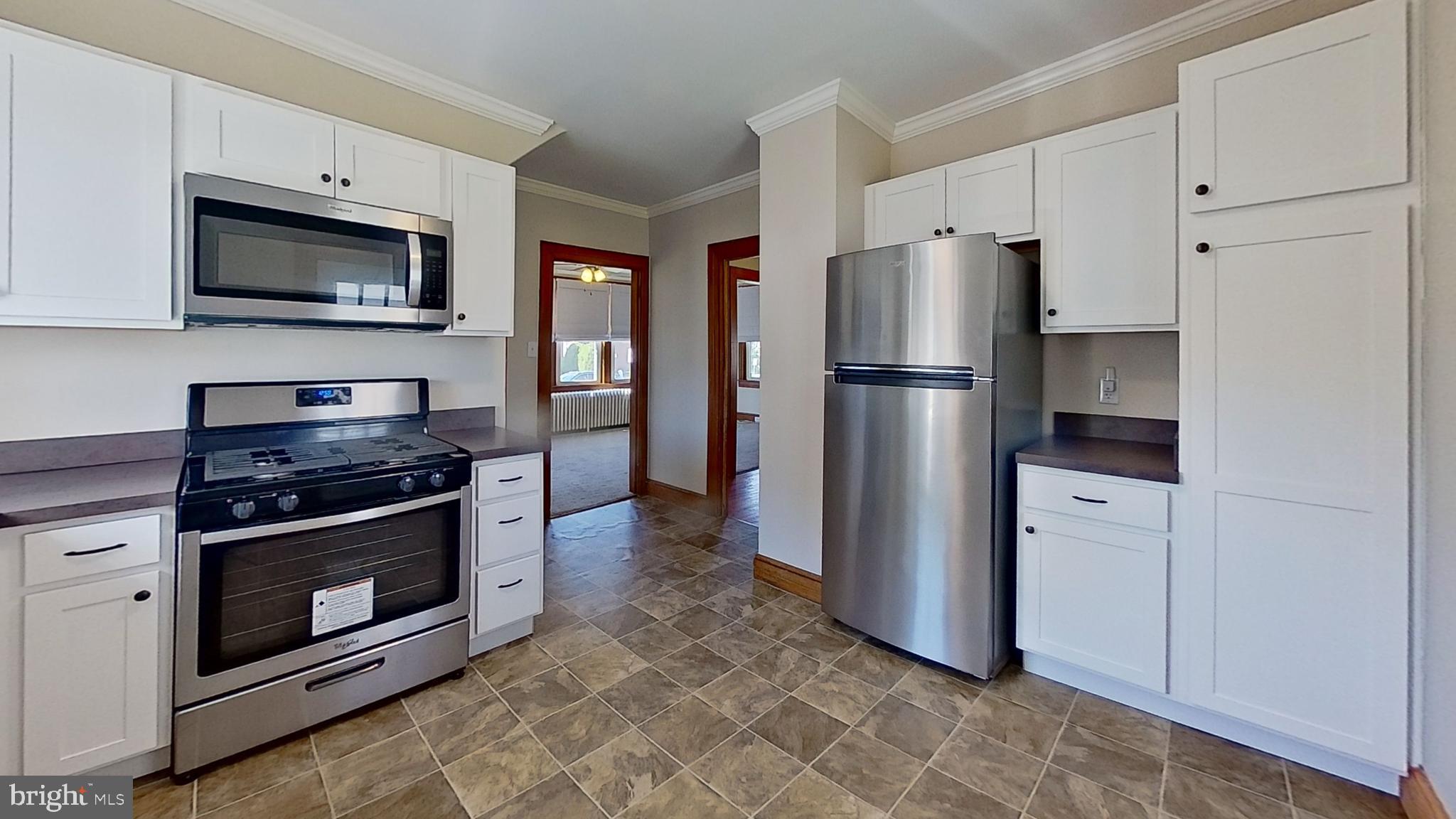 549 Lancaster Avenue York, PA 17403 - Photo 11 of 11 a kitchen with stainless steel appliances white cabinets a stove a microwave and a refrigerator