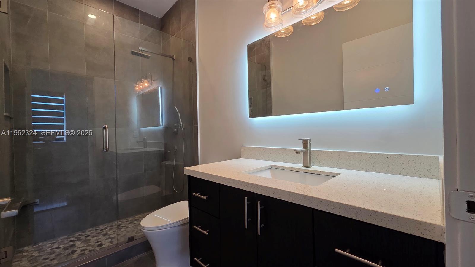 17820 Northwest 73rd Avenue, Unit 2031 Hialeah, FL 33015 - Photo 5 of 11 a bathroom with a sink vanity toilet and a mirror
