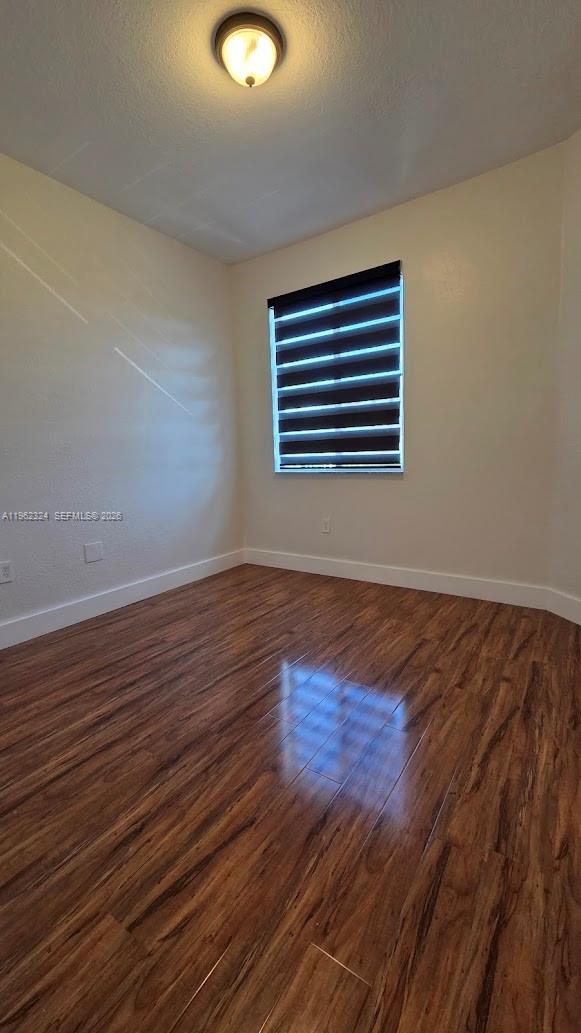 17820 Northwest 73rd Avenue, Unit 2031 Hialeah, FL 33015 - Photo 7 of 11 a view of an empty room with wooden floor and a window