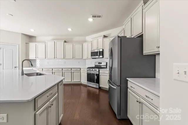 a kitchen with white cabinets and stainless steel appliances