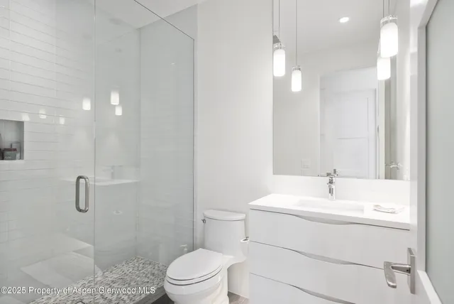 a bathroom with a sink a toilet and shower