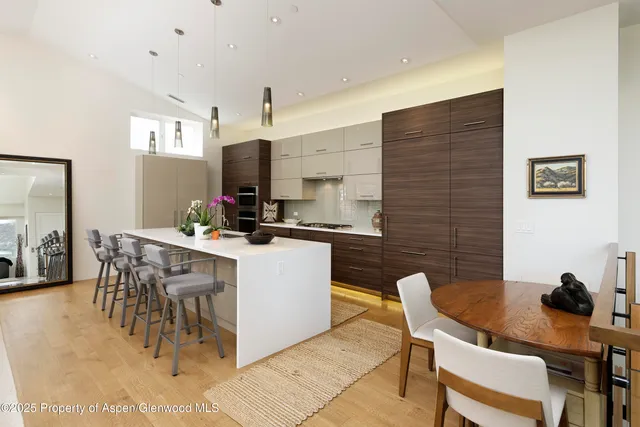 a kitchen with a dining table chairs and a refrigerator