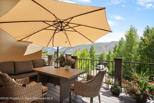 a balcony with furniture and umbrella