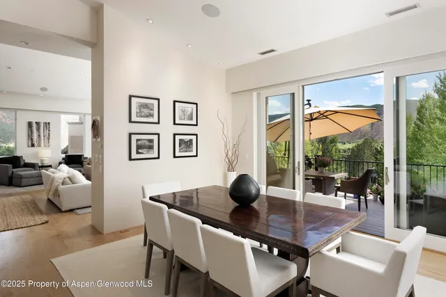 a dining room with wooden floor and glass door