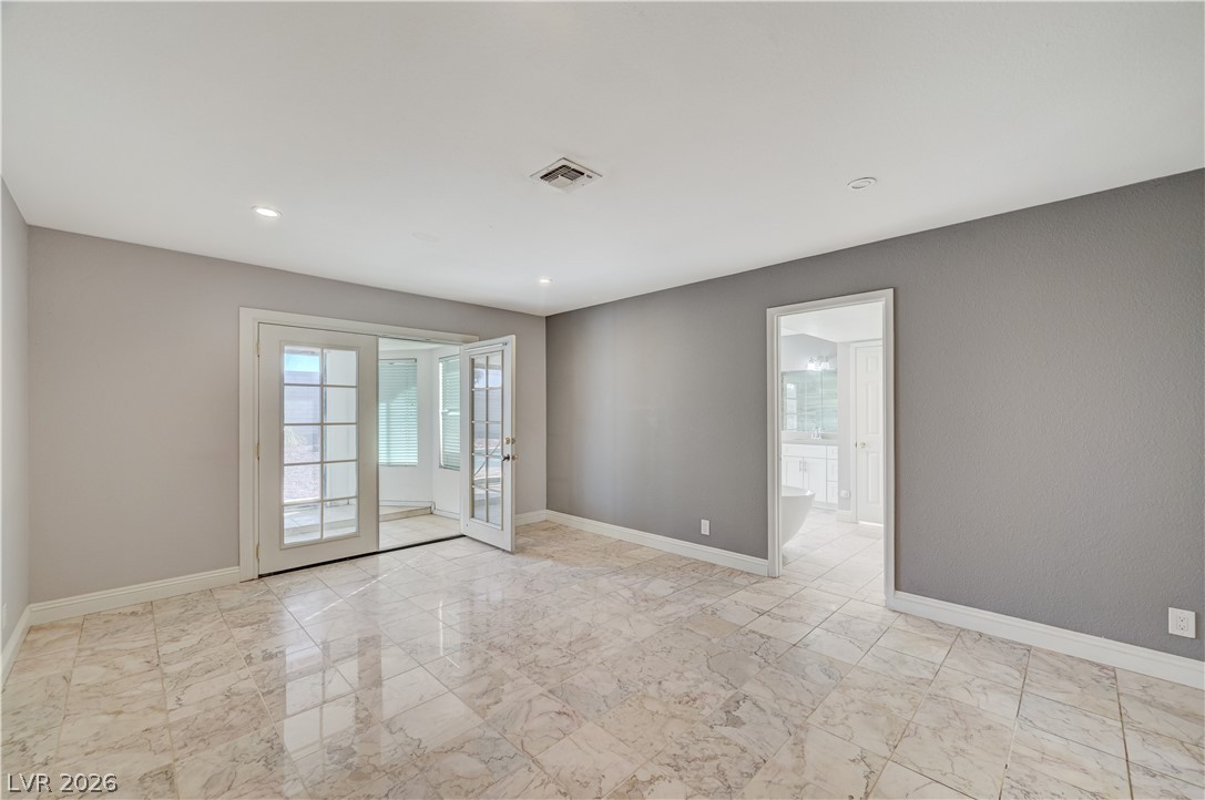 6635 Costa Brava Road Las Vegas, NV 89146 - Photo 26 of 59 Natural light floods this versatile room, featuring a private entrance to an outdoor space and seamless access to an adjacent primary bathroom.