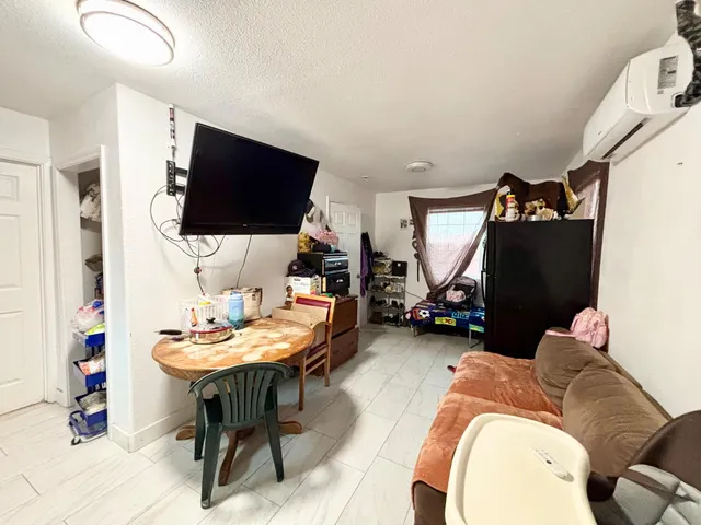 a living room with furniture a flat screen tv and kitchen view