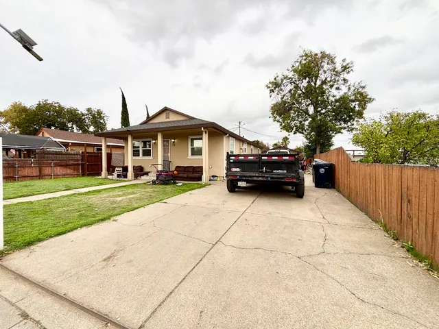 a car parked in front of a house with a garden