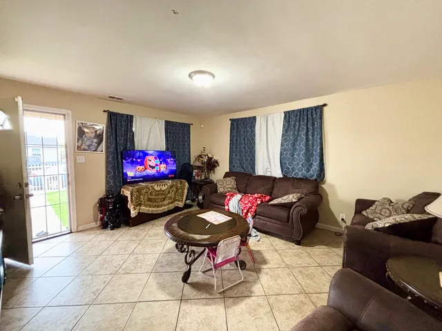 a living room with furniture a flat screen tv and a window