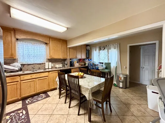 a kitchen with stainless steel appliances granite countertop a sink a stove a dining table and chairs