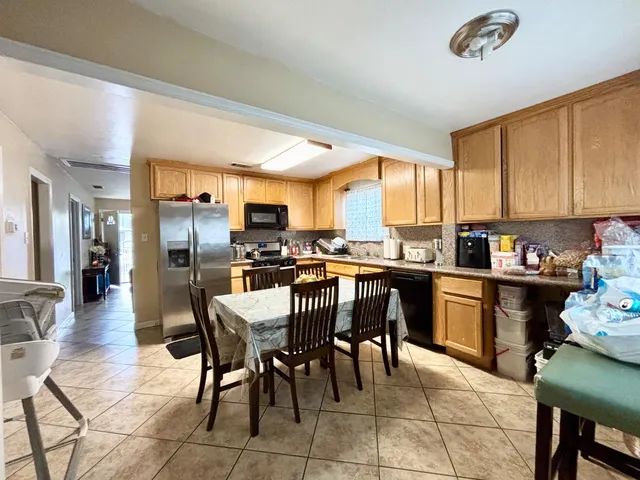 a kitchen with a dining table chairs and refrigerator