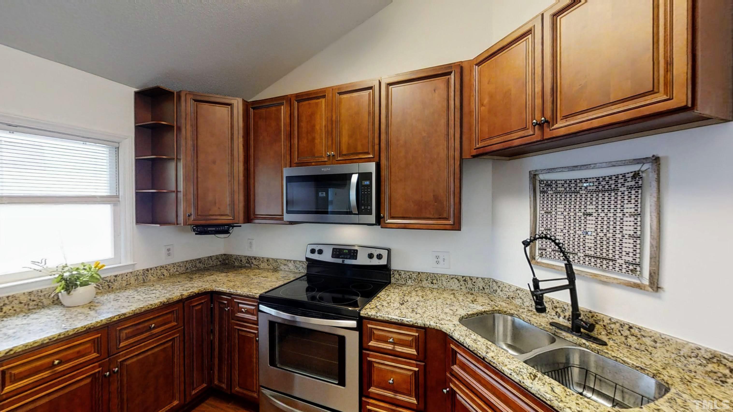 424 Dickens Drive Raleigh, NC 27610 - Photo 12 of 33 a kitchen with granite countertop a sink a stove and cabinets
