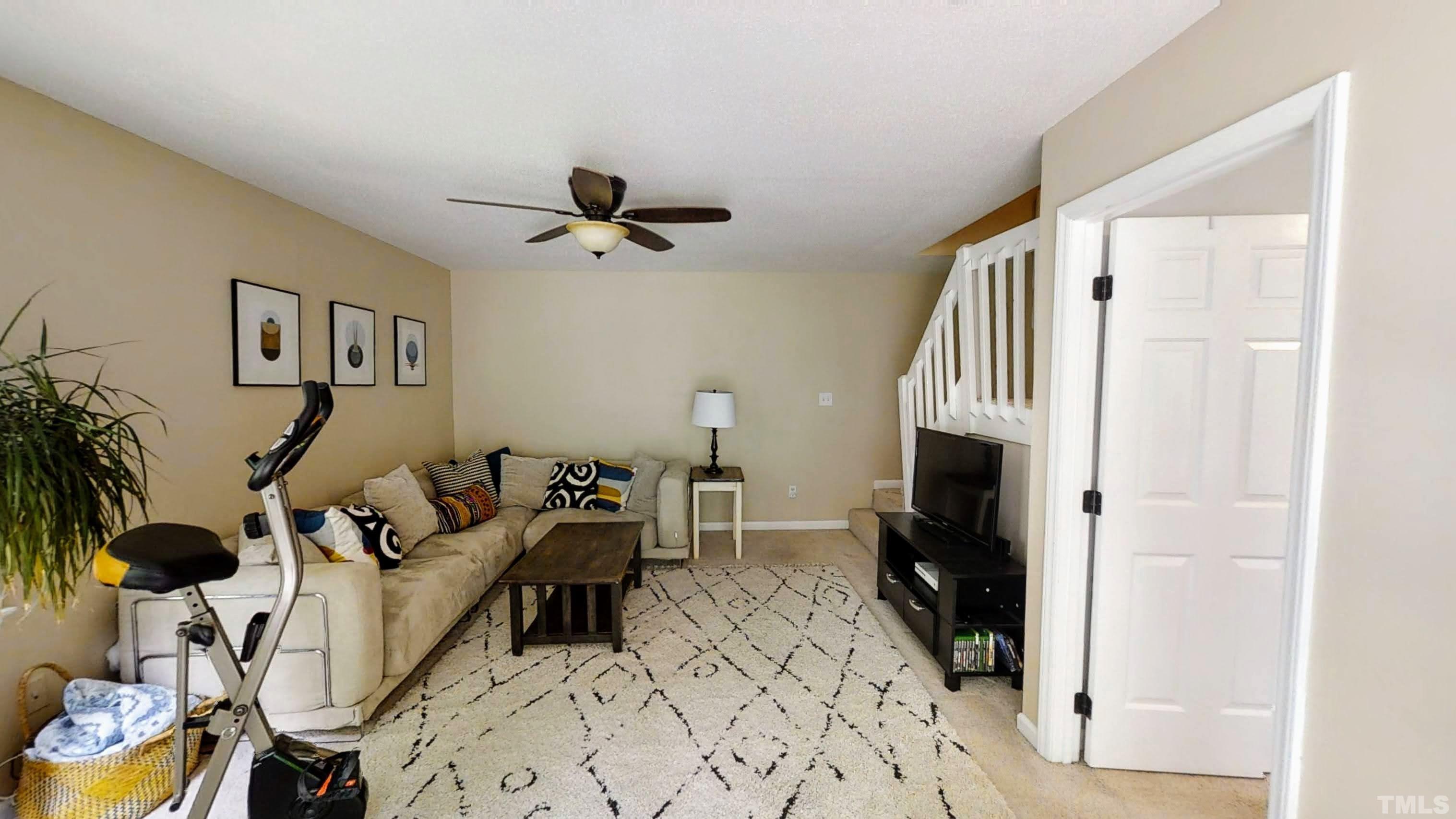 424 Dickens Drive Raleigh, NC 27610 - Photo 27 of 33 a living room with furniture a fireplace and a flat screen tv