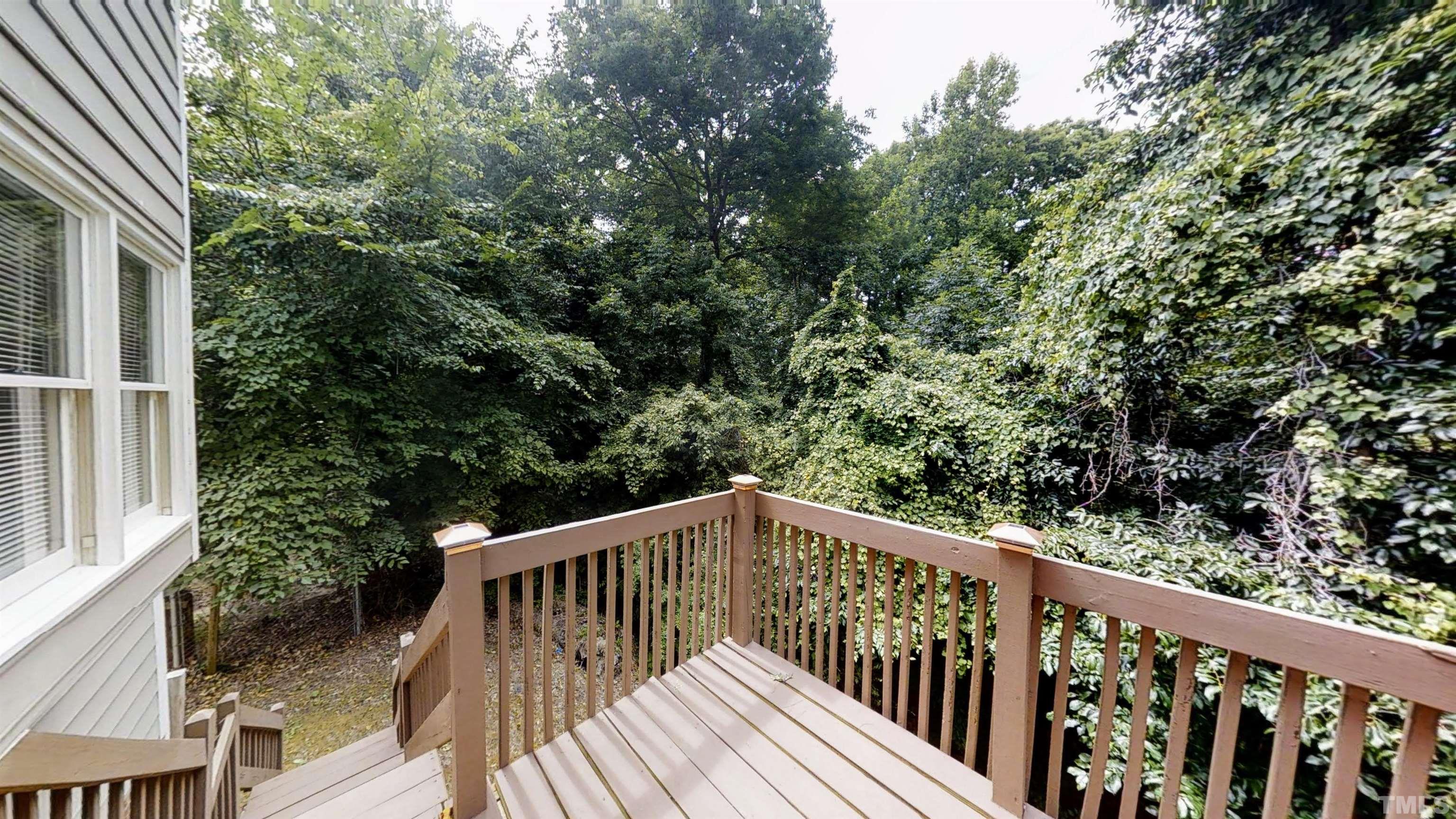 424 Dickens Drive Raleigh, NC 27610 - Photo 32 of 33 a balcony with wooden floor and trees in the back