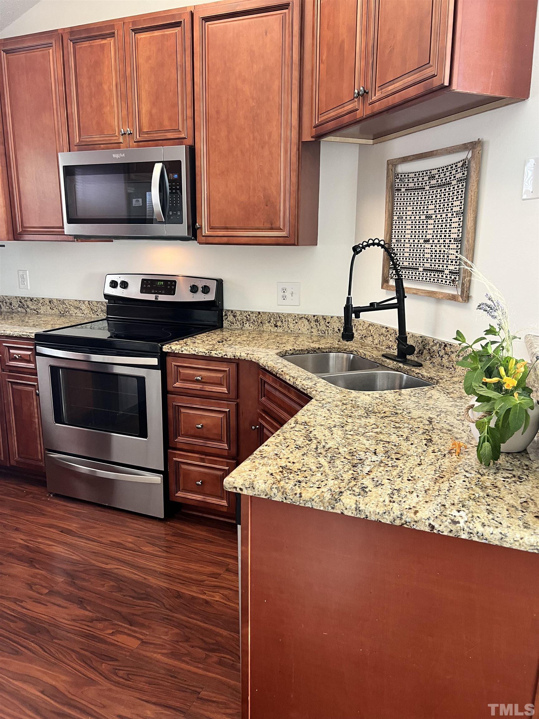 424 Dickens Drive Raleigh, NC 27610 - Photo 5 of 33 a kitchen with a stove and a microwave