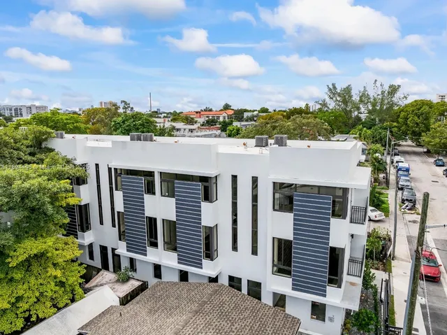 an aerial view of a house with a yard and balcony