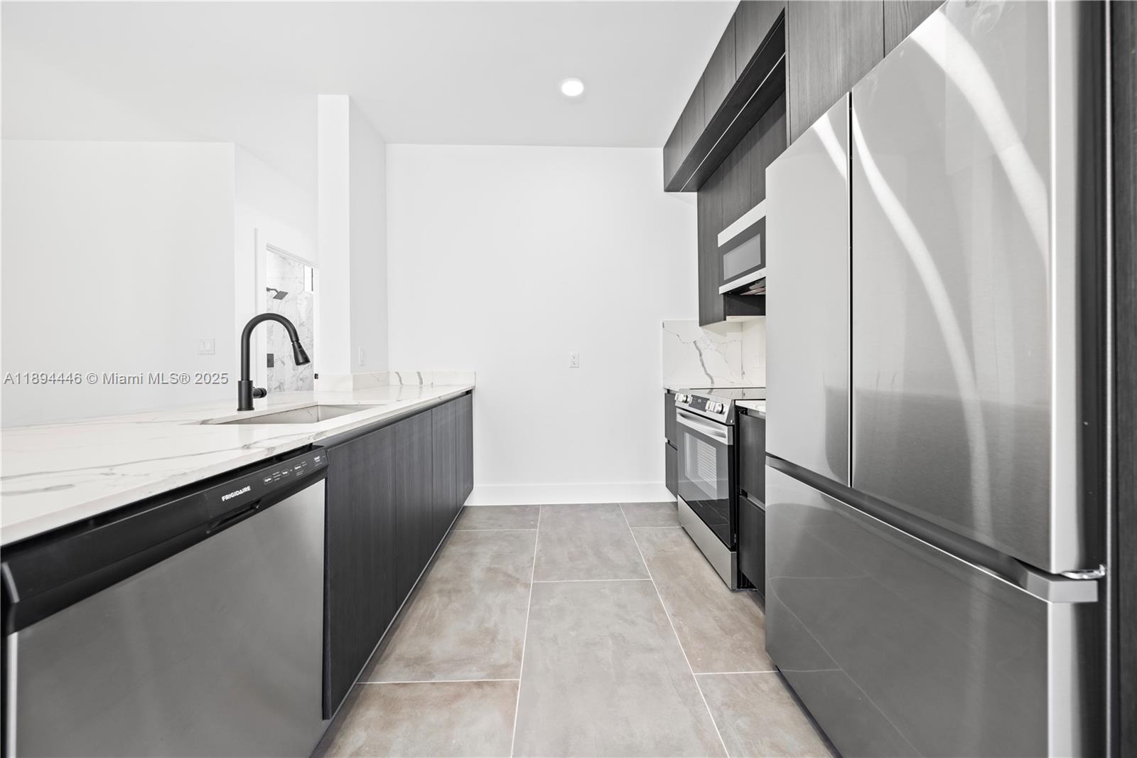 526 Southwest 2nd Street, Unit 1 Miami, FL 33130 - Photo 7 of 36 a kitchen with stainless steel appliances granite countertop a refrigerator a sink and a stove